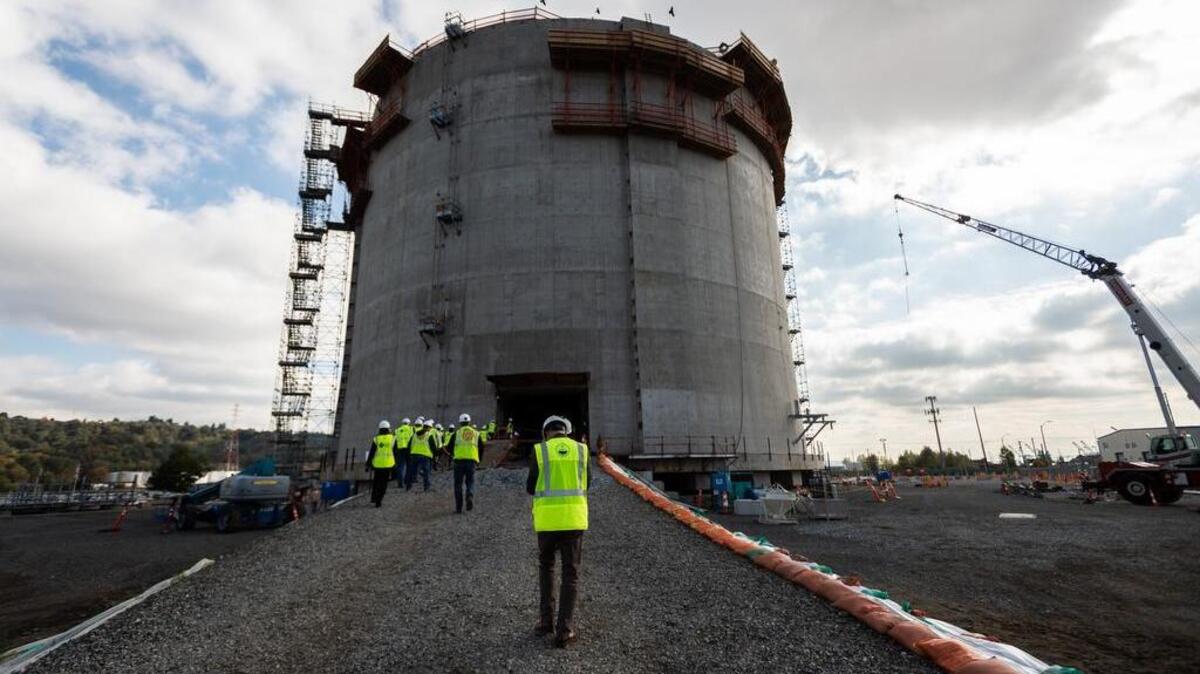 Visitors approach the 8-million-gallon holding tank at the liquefied natural gas plant under construction on the Tacoma Tideflats.