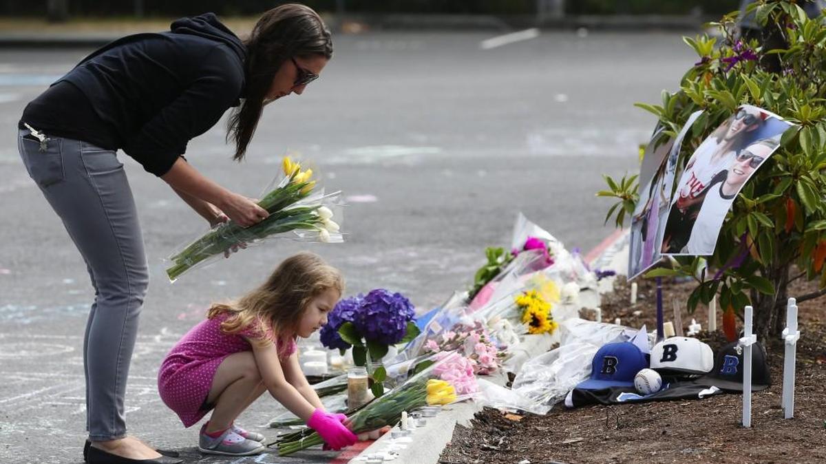A mother and daughter visit a memorial site in Mukilteo after the July 2016 house party slaying of three young people by a 19-year-old with an assault weapon. In Washington, as in most states, he was able to buy and possess the weapon legally even though he’s not 21.