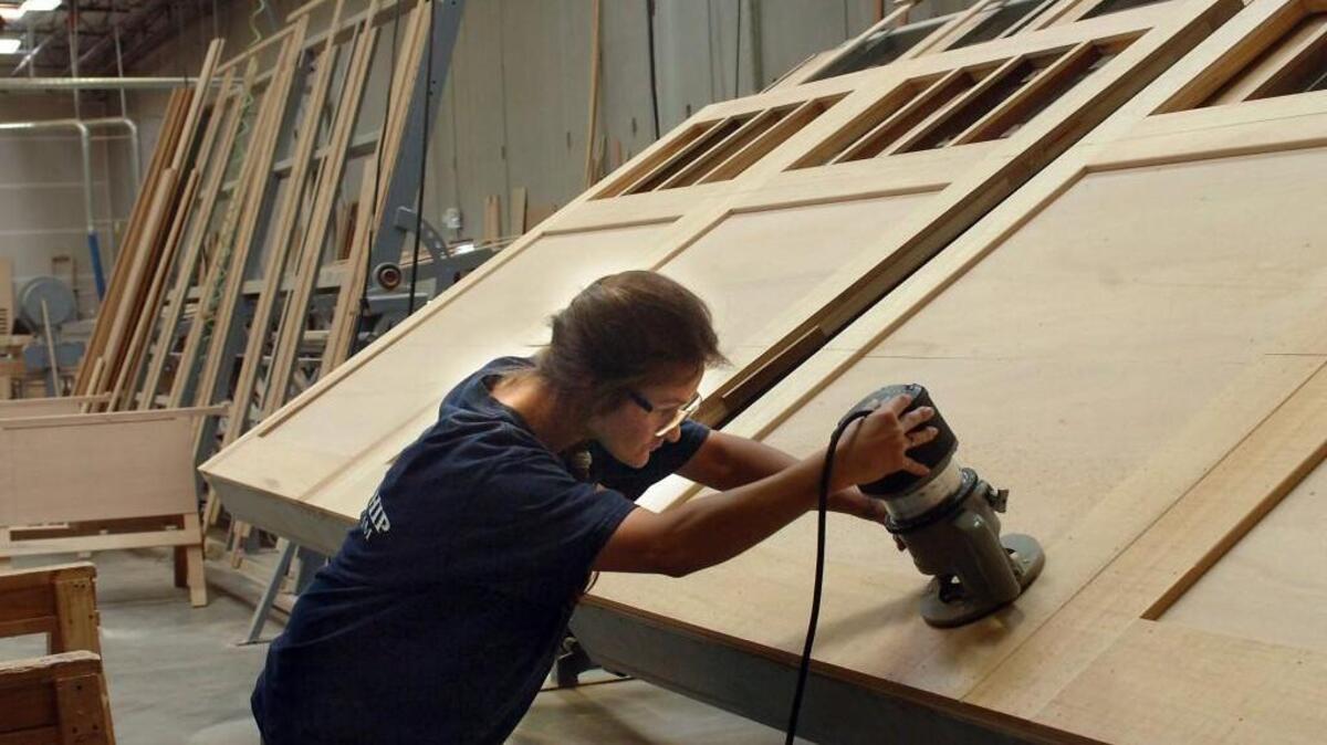 An employee uses a router as she works in the custom door woodshop at the Northwest Door plant in Frederickson. The local company exports its products to countries including Australia, New Zealand and Japan.