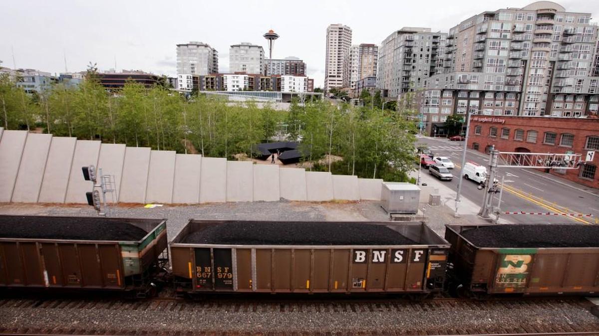 A train hauling coal to British Columbia heads north out of downtown Seattle and in view of the Space Needle. The Seattle City Council was among the cities that passed a resolution opposing the development of coal-export terminals in Washington state over concerns about increased train traffic and potential harm to health and the environment.