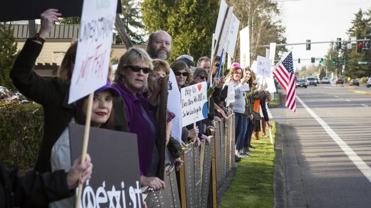 Dozens of people line Point Fosdick Drive Northwest during a protest on Friday. They showed up to oppose a Tacoma Narrows Tea Party event hosting an anti-Islam speaker at the Gig Harbor Library. However, the event was quietly moved to another location, leaving several would-be-attendees outside the locked library doors.