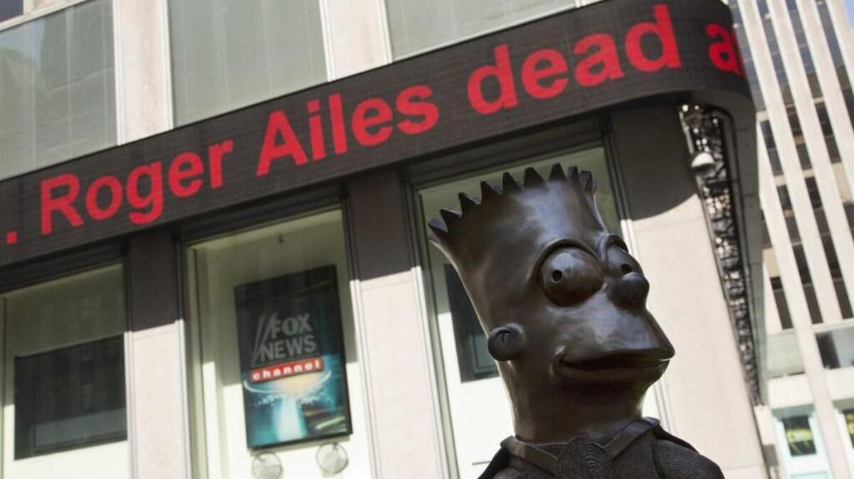 A news ticker on the News Corporation building in New York City announces the death of former Fox News Chairman and CEO Roger Ailes on Thursday. A bust of Fox cartoon character Bart Simpson stands nearby.
