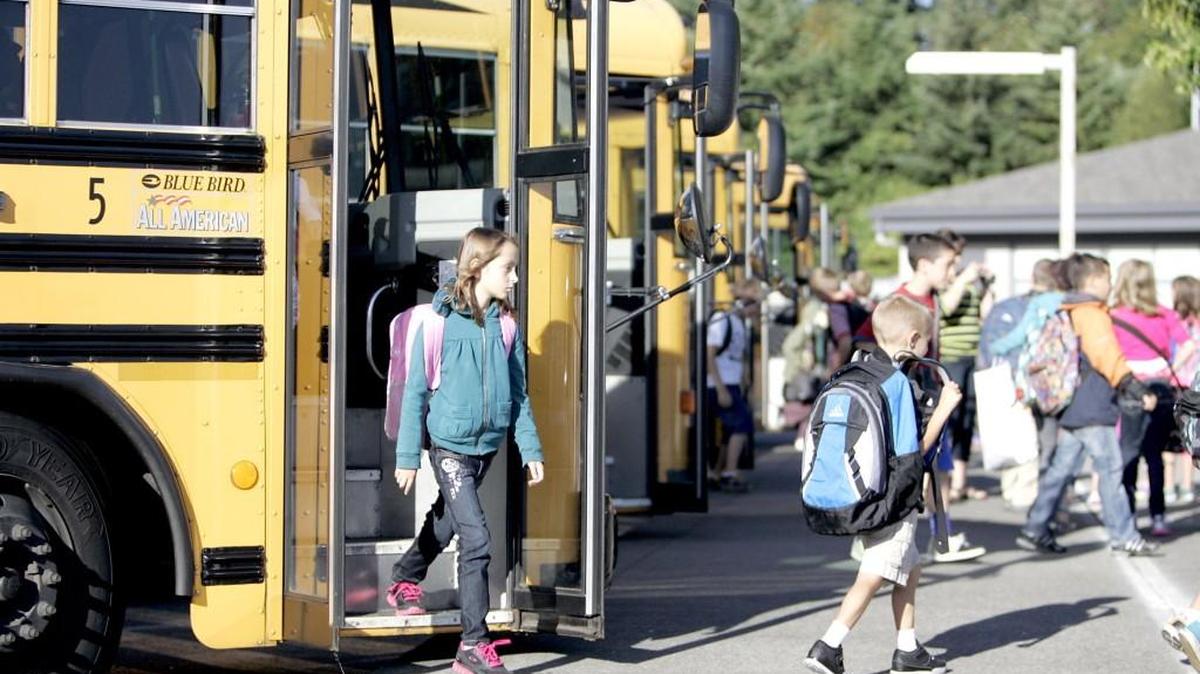 Kids arrive by bus before heading into class at Harbor Heights Elementary School in the Peninsula School District in August 2017. Meanwhile, the debate and court orders over Washington’s K-12 school funding system go round and round.