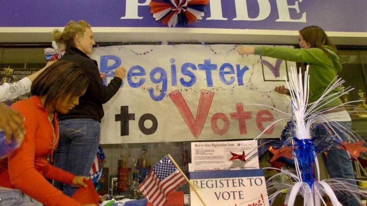 Voter registration volunteers prepare their informational sign-up table in the North Thurston High School cafeteria before the 2008 presidential election. Washington voter registration and election management systems would be integrated under a proposal this year by Secretary of State Kim Wyman.