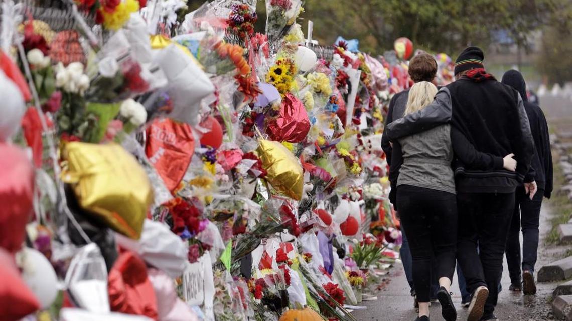 People pass a memorial outside Marysville-Pilchuck High School in Marysville, Washington, several days after a deadly shooting in the school cafeteria in October 2014.