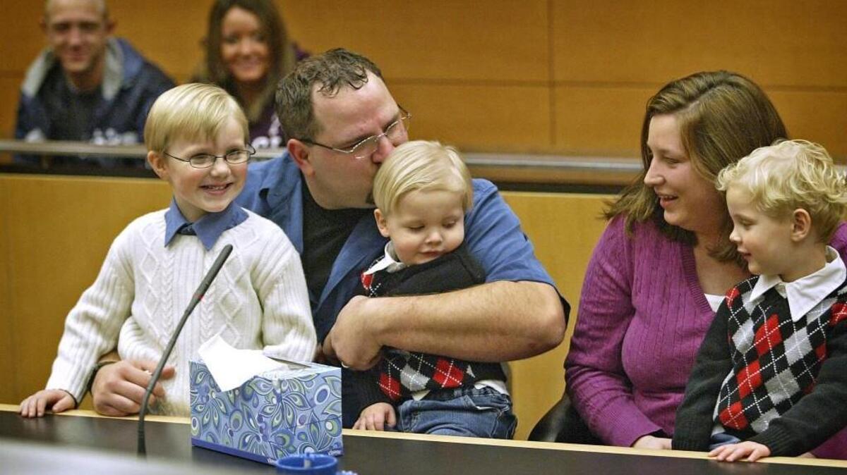An emotional Michael Morrison of Spanaway kisses newly adopted son William, 19 months old, during a National Adoption Day event at Pierce County Juvenile Court in 2009. Beaming older brother Michael, left, and Gabriel, right (sitting with mom Jennifer), enjoy the moment.