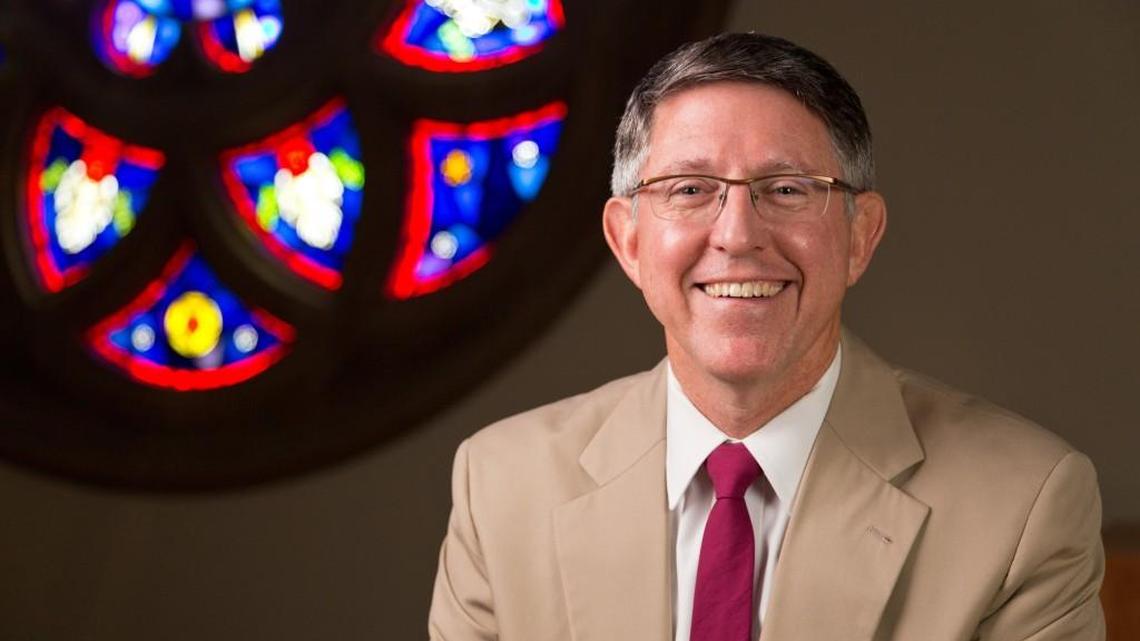 Pacific Lutheran University President Thomas W. Krise in front of the rose window in the Ness Family Chapel of the Karen Hille Phillips Center at PLU in August 2014. Photo by