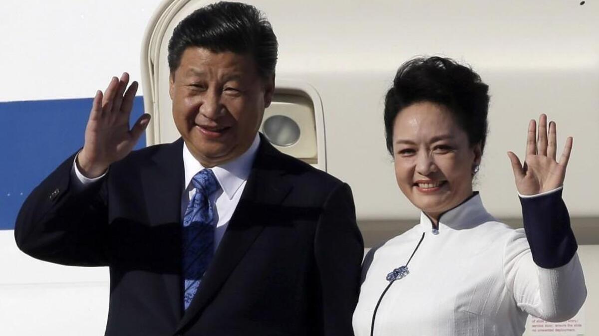 The Five Spot salute is delivered handsomely by Chinese President Xi Jinping, left, and his wife Peng Liyuan after they arrived at Boeing Field in Everett in September 2015. Xi’s visit to the Pacific Northwest precipitated a Chinese government-hosted visit to Asia by Tacoma students from Lincoln High School this month.