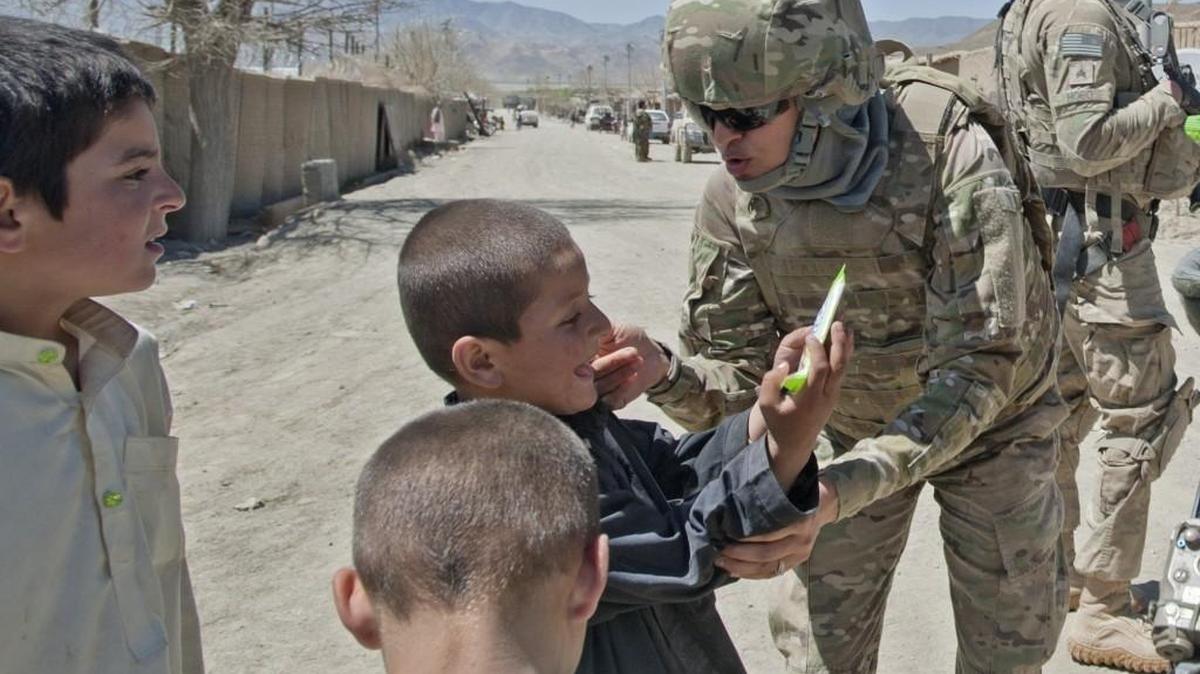 An interpreter traveling with JBLM troops chats with boys in Zabul Province, Afghanistan, during a 2012 combat deployment. While U.S. soldiers treat children with respect, the same can’t always be said for their Afghan security force counterparts.