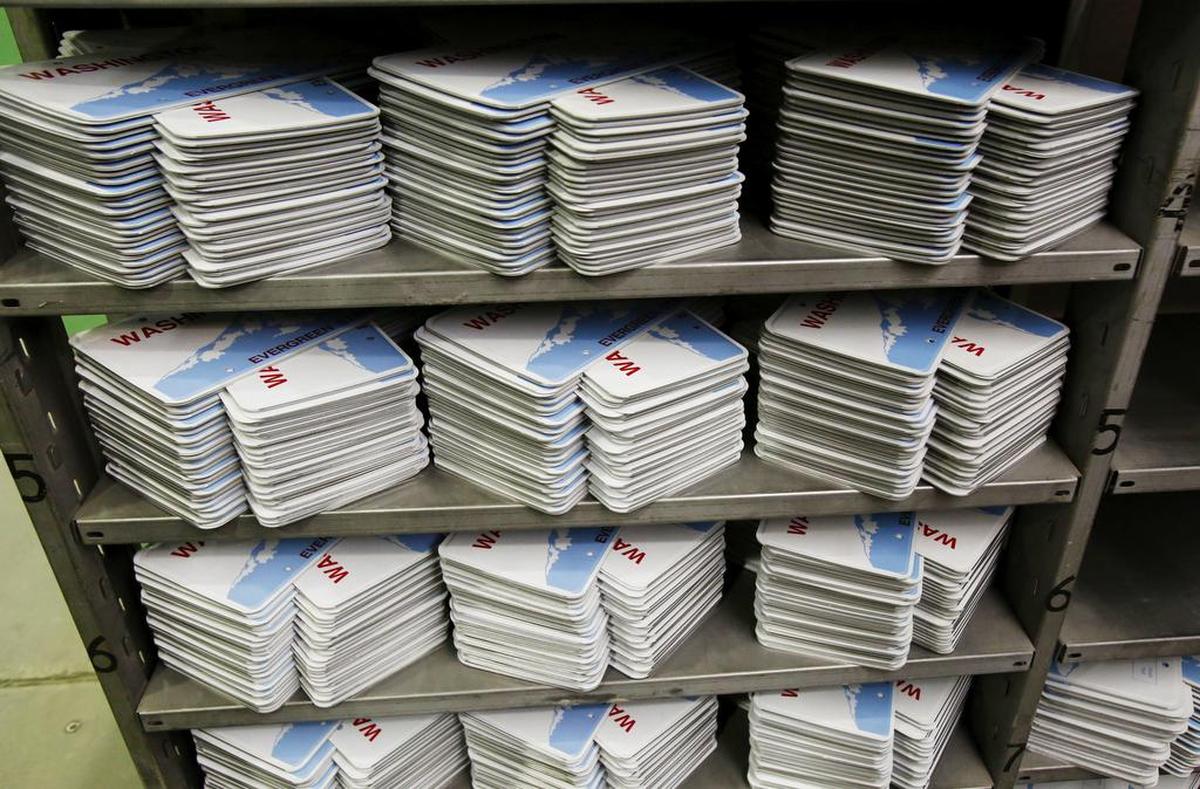 Washington license plates are stacked, waiting to be embossed with numbers at the state penitentiary in Walla Walla. License-plate replacement is one of the most unpopular rules in the state. 