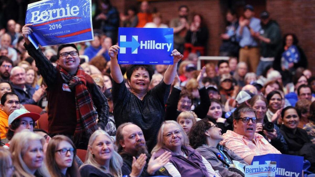 Bernie Sanders supporter Stephen Wong, left, and Hillary Clinton supporter Benita Lozano stand up for their candidates Saturday at the Democratic party caucus in Anchorage, Alaska.