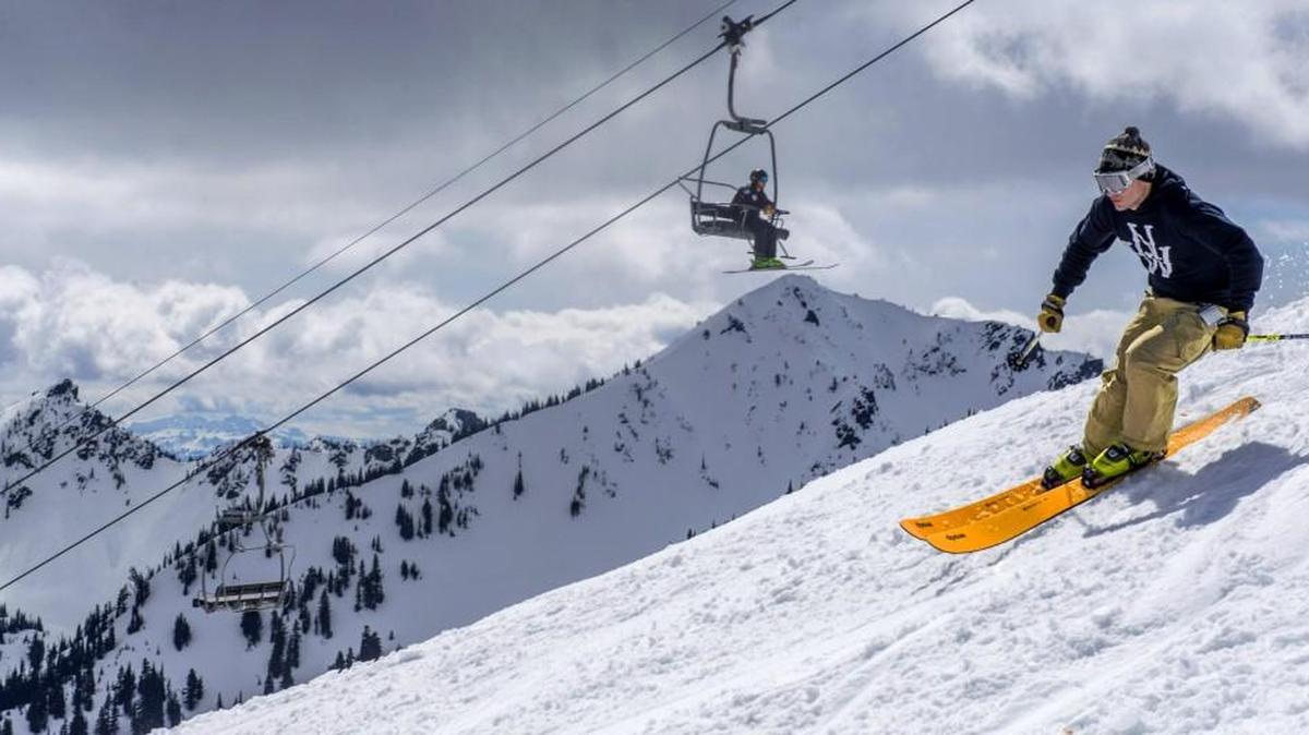 A skier cruises under Rainier Express on a warm and sunny spring day at Crystal Mountain in 2016.