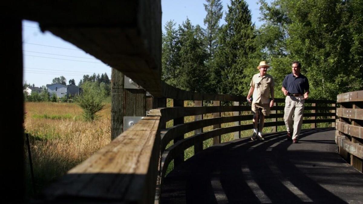 Ernie Bay, left, a trail activist from Puyallup, walks the Nathan Chapman Memorial Trail with Sen. Jim Kastama in 2005. The trail is named after the first U.S. casualty in Afghanistan, Nathan Chapman from South Hill. Bay, who dedicated years to South Sound trails, died March 18.