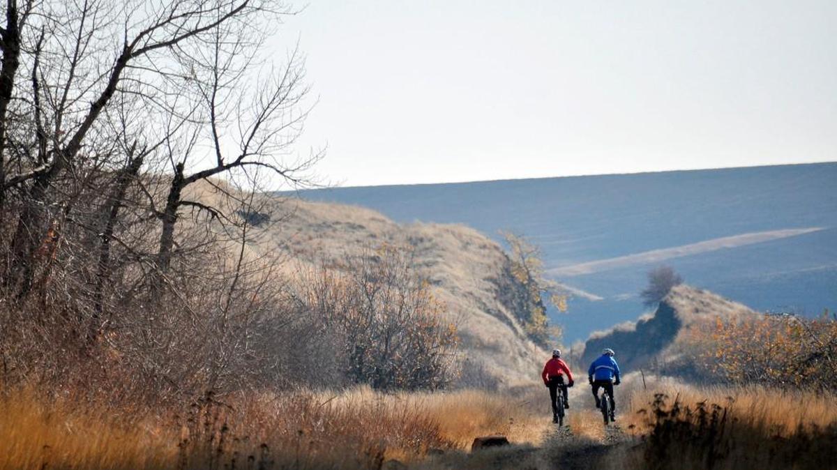 Chip Andrus, left, and Pat Sprute of Spokane cycle on the abandoned railway called the John Wayne Trail near Rosalia.
