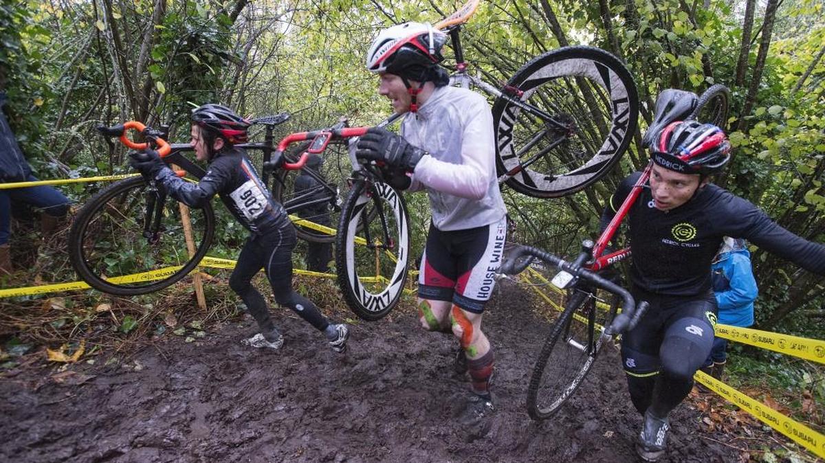 Competitors in the Subaru Cyclo Cup cyclocross race carry their bikes through an intentionally muddy run-up in an open race at Fort Steilacoom Park in Lakewood in 2015.
