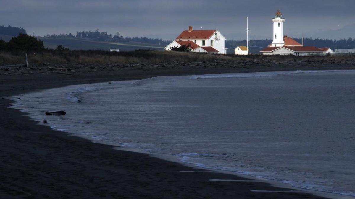 A beam of sunlight hits the Point Wilson Lighthouse at Fort Worden State Park adjacent to Port Townsend. The light marks Admiralty Inlet where the Strait of San Juan de Fuca meets Puget Sound.