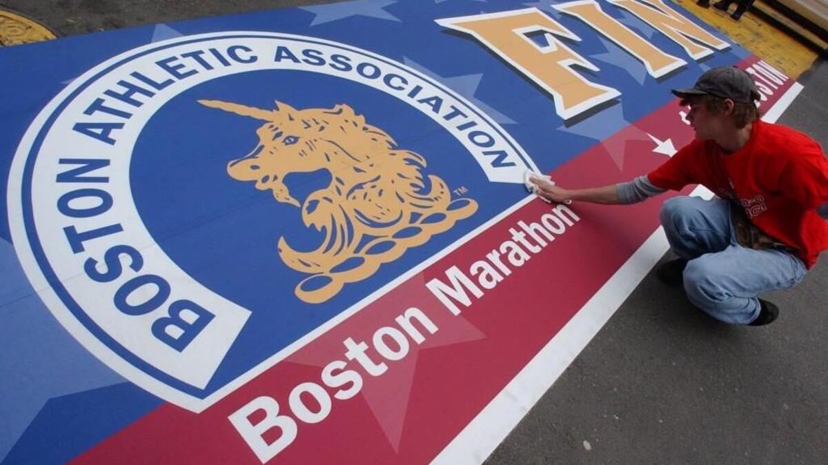 Albert Turner, of Beverly, Massachusets, cleans the finish line for the Boston Marathon in 2006.