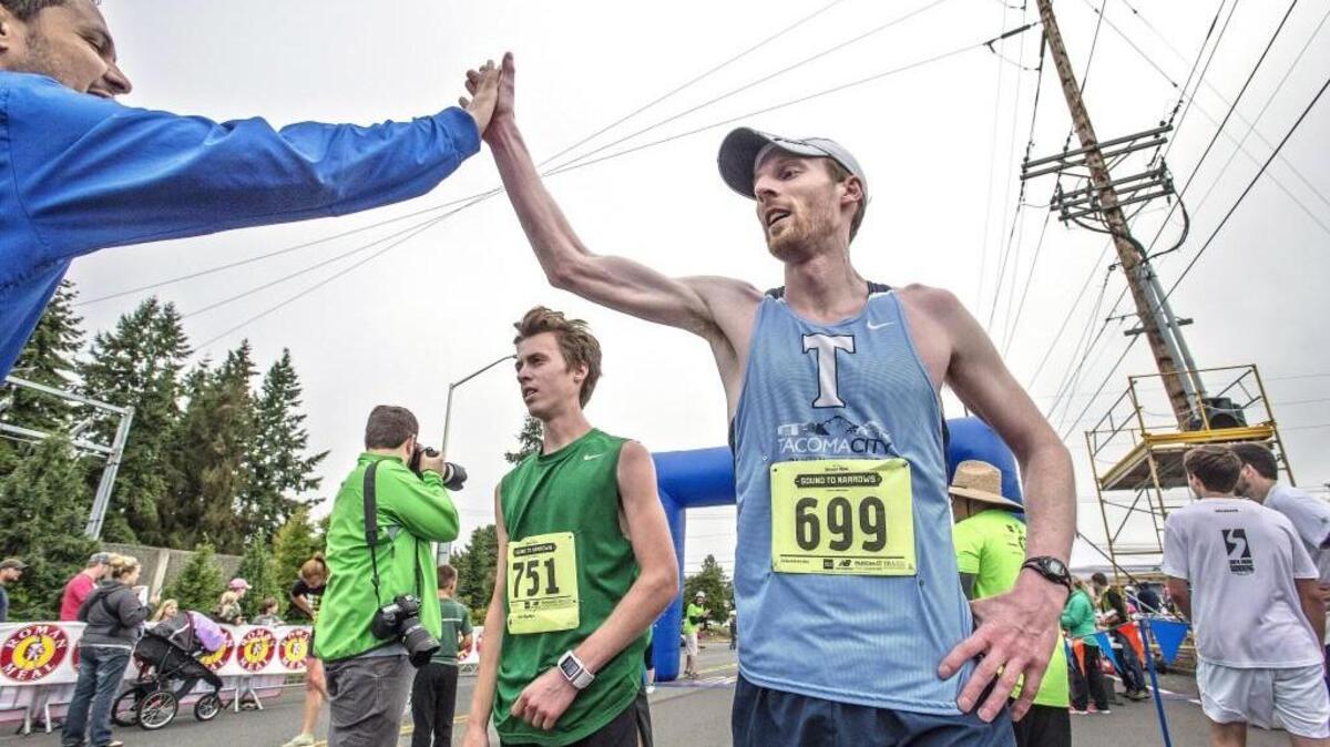 Dan McLean, 33 of Tacoma , right, high fives a friend after he won the men's 12K race during the 43rd annual Sound to Narrows in 2015.