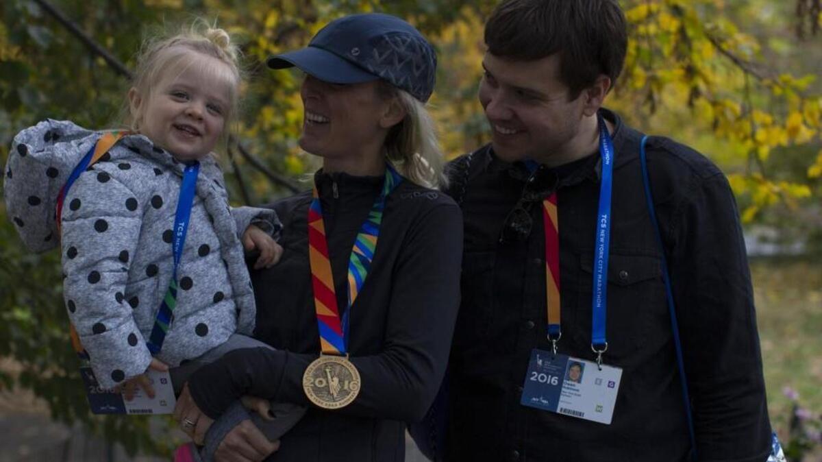 Sarah Robinson celebrates with her family — daughter, Penelope, and husband, Owen — after finishing the New York City Marathon. The Tacoma resident was the top South Sound finisher, covering the 26.2-mile course in 2:51:50.