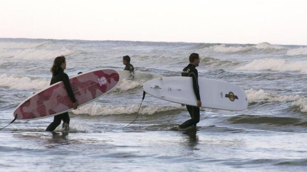
Surfers enter and leave a surf spot at Westhaven State Park. The park is the north end of 18 miles of public beach, so surfers can easily find uncrowded waves. 
