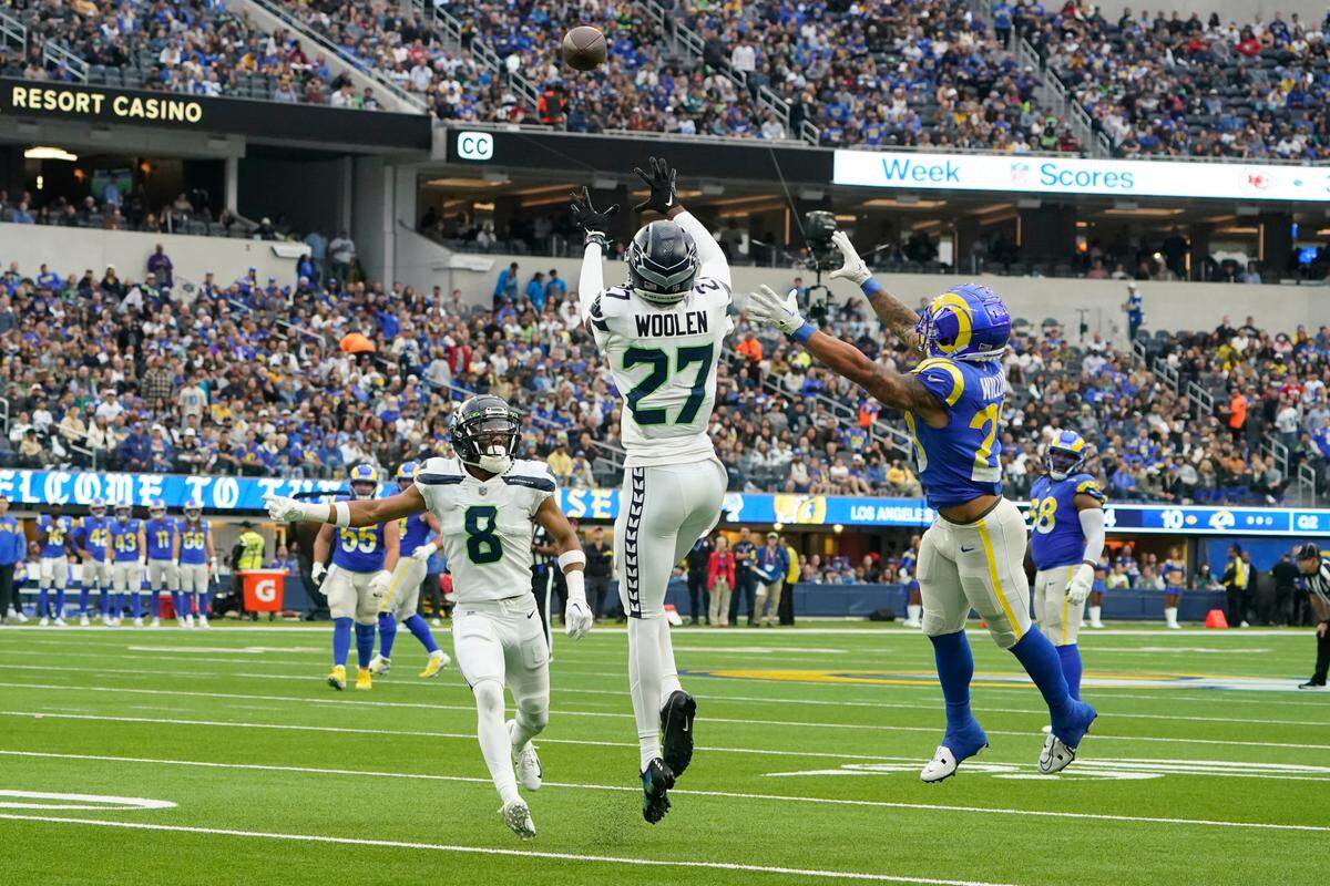 Seattle Seahawks cornerback Tariq Woolen (27) intercepts a pass intended for Los Angeles Rams running back Kyren Williams, right, as Seahawks cornerback Coby Bryant (8) watches during the first half of an NFL football game Sunday, Dec. 4, 2022, in Inglewood, Calif. (AP Photo/Marcio Jose Sanchez)