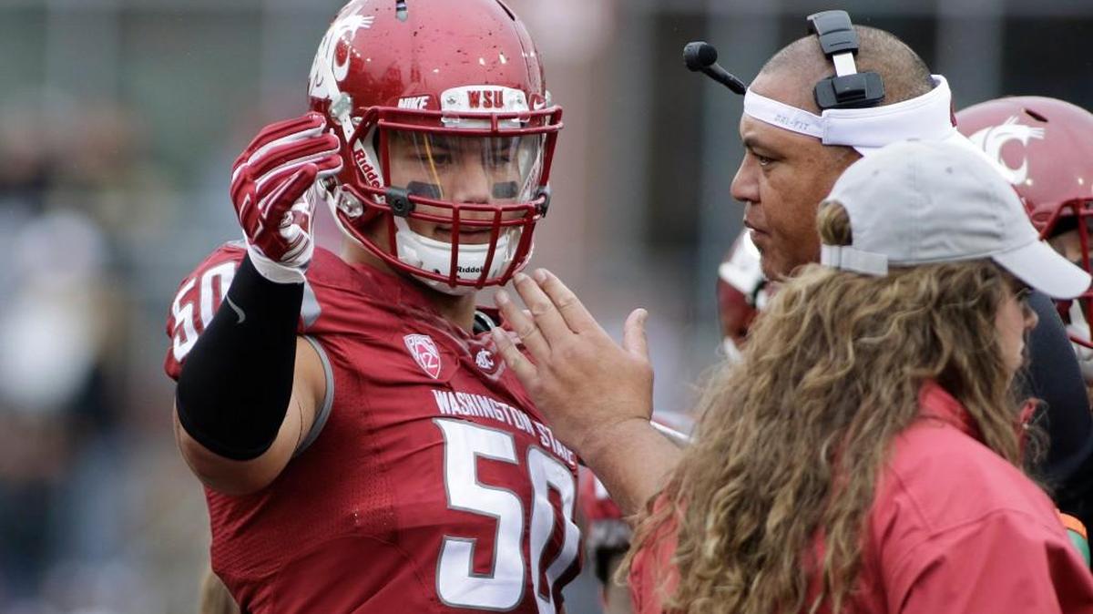 Washington State defensive end Hercules Mata'afa credits former assistant head coach and defensive line coach Joe Salave'a, at right with headset, for convincing him to play for the Cougars. Salave’a is now coaching at Oregon.