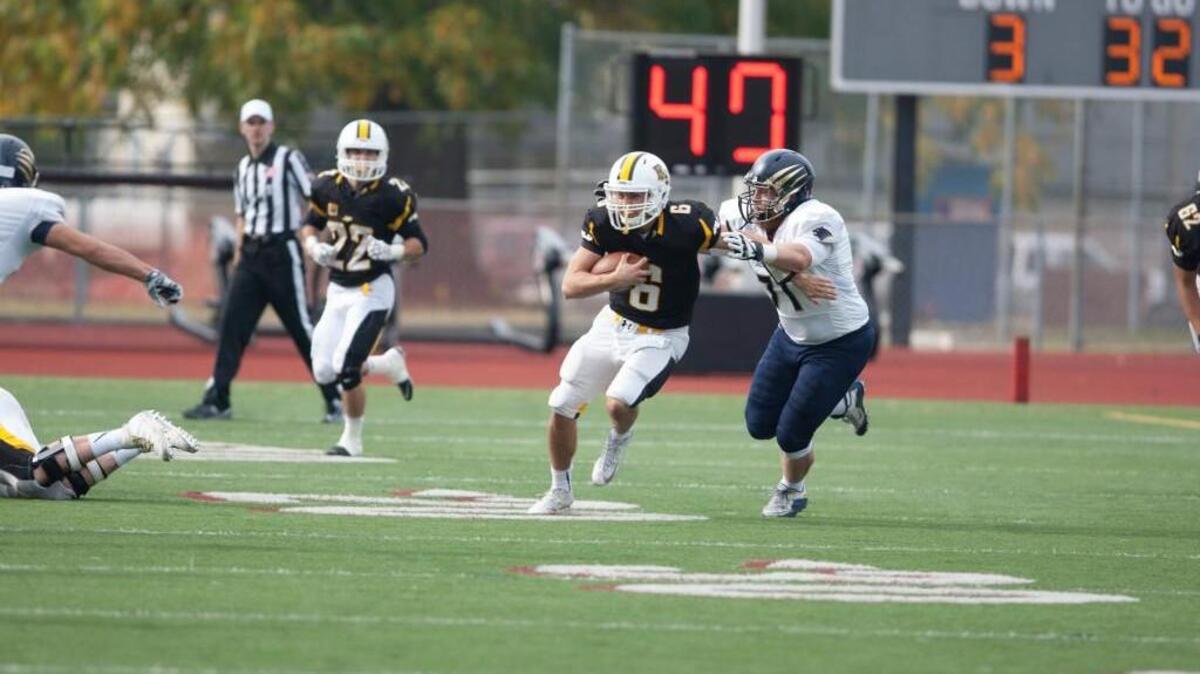Quarterback Cole Chandler (6) runs the ball against George Fox earlier this season. Chandler, who began the year as the backup, made his first career start in this game, earning the win in the process.