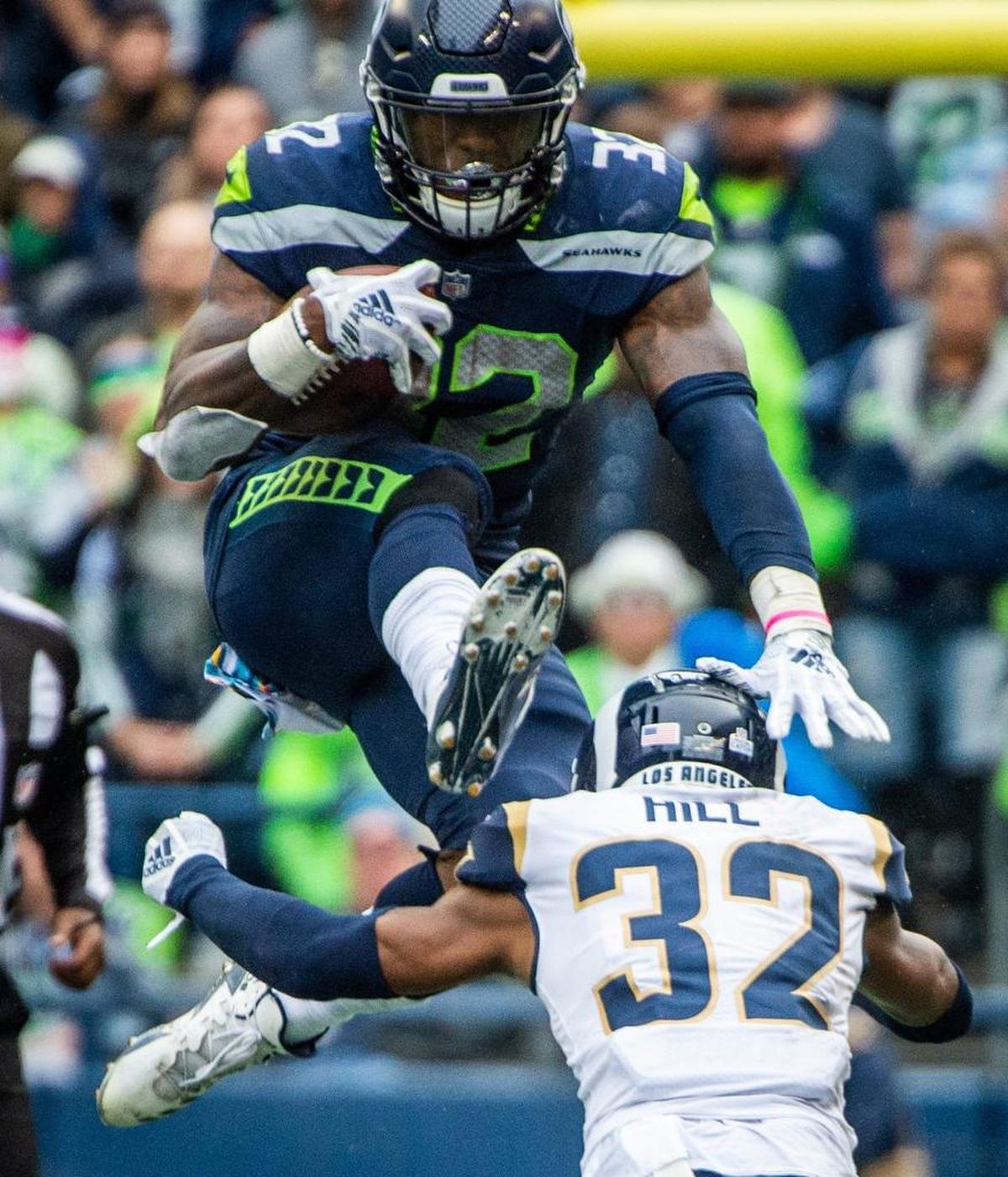 Seahawks lead running back Chris Carson (32) hurdled Rams cornerback Troy Hill (32) during a run in last month’s loss to Los Angeles in Seattle. Carson had a 100-yard day that game, but was inactive Sunday when the Seahawks played the Rams in Los Angeles.