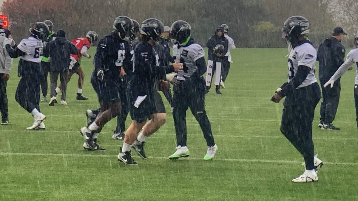 Bobby Wagner (center, in white) and the Seahawks practicing in pouring rain at team headquarters in Renton Friday, Nov. 10, 2023, to play the Washington Commanders.