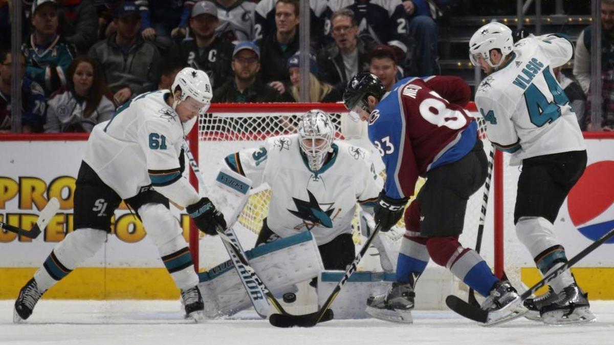 San Jose Sharks goaltender Martin Jones (31) watches as Sharks defenseman Justin Braun (61) and Avalanche left wing Matt Nieto (83) battle for the puck as Sharks defenseman Marc-Edouard Vlasic (44) moves into the play in the second period of an NHL hockey game in Denver on Thursday, Jan. 18, 2018