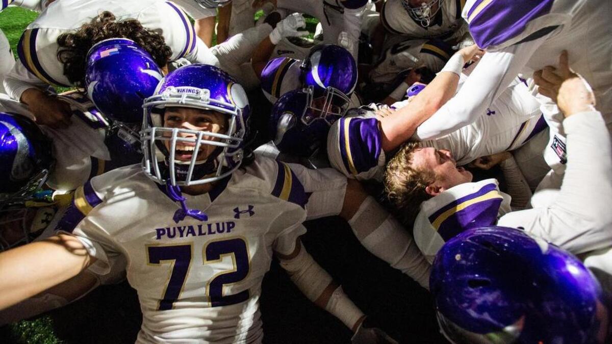 Puyallup players pile onto Ben Rodriguez after his game-sealing interception in overtime. Graham-Kapowsin played Puyallup in a football game at Art Crate Field in Spanaway, Wash., on Friday, Sept. 21, 2018.