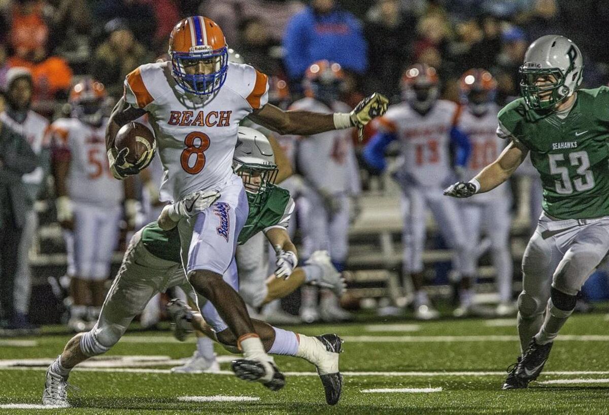 Vikings wide receiver Mason Starling (8) is tackled by Seahawks safety Nick Eberhardt (24) during the 3A state quarterfinal football game between Peninsula High School Seahawks and Rainier Beach High School Vikings at Roy Anderson Field in Purdy, Wash., Friday, Nov. 17, 2017. Rainier Beach wins 37-28.