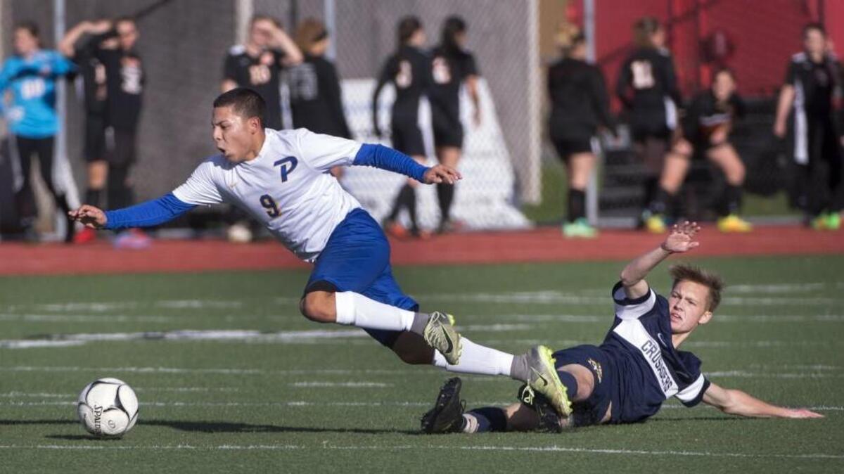 Prescott’s Jose Gonzalez avoids a slide tackle by Seth Talen of Tacoma Baptist. The Tigers defeated the Crusaders, 1-0.
