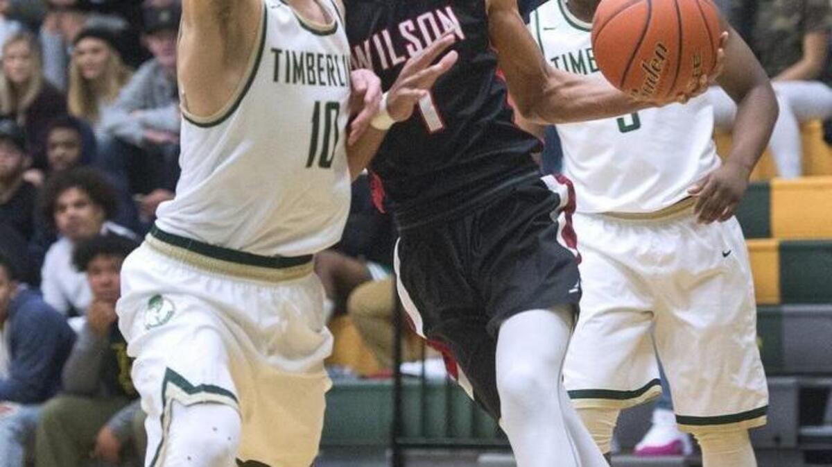 Wilson forward Emmitt Matthews Jr. bangs into Timberline guard Erik Stevenson on a drive to the basket. Photo taken in Tacoma on Monday, Jan. 16, 2017.