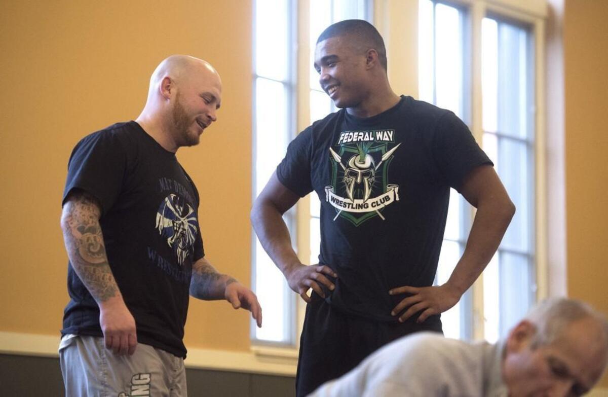 Lincoln senior J.J. Dixon - the defending state champion at 182 pounds - talks with head coach Willie Ross during wrestling practice at Lincoln High School in Tacoma on Tuesday, Jan. 30, 2018.
