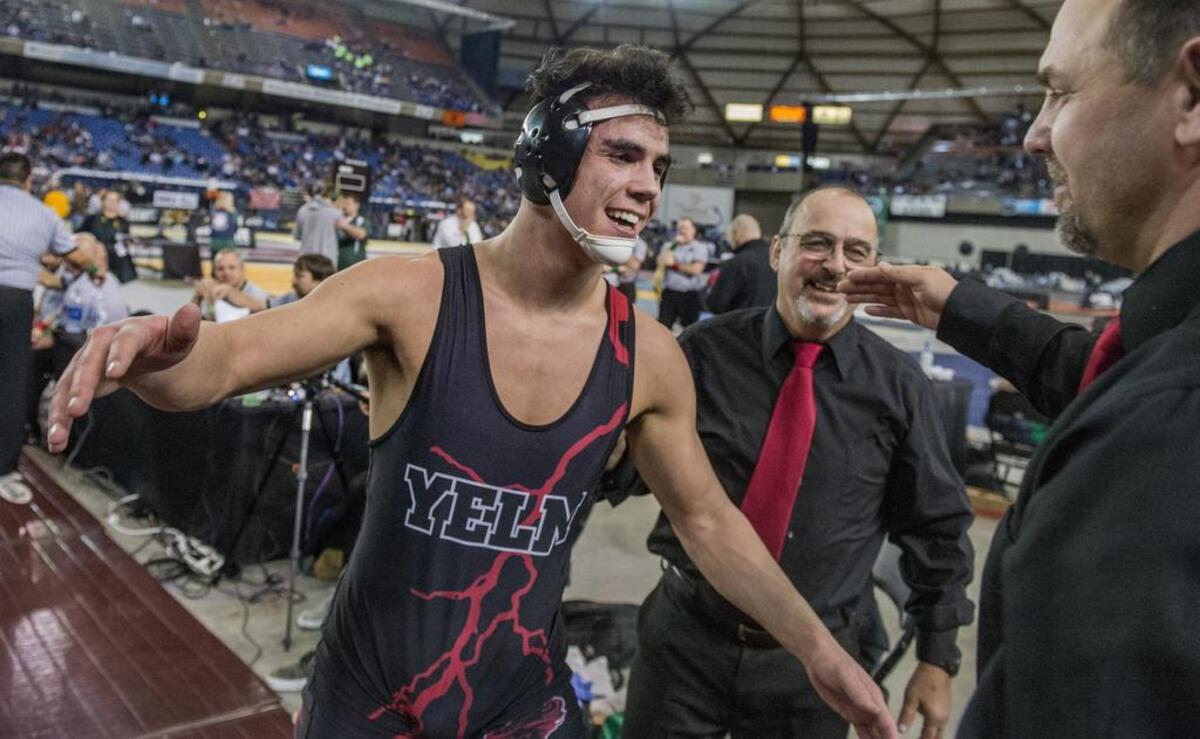 Derrick Platt of Yelm goes for a jug with his coaches after winning the boys AAA 182-pound weight class championship round of the Thirtieth Mat Classic state wrestling tournament held in the Tacoma Dome, February 17, 2018.