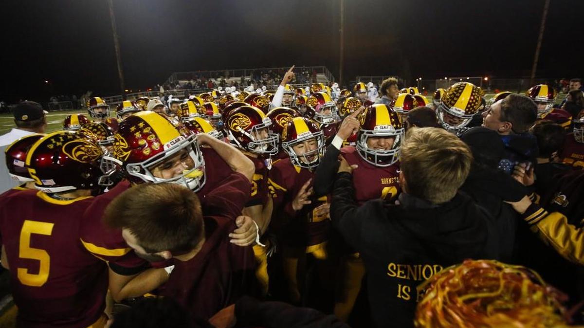 Players and students rush the field following Enumclaw's win. Enumclaw played Auburn Riverside in a football game at Enumclaw Stadium in Enumclaw, Wash., on Friday, Oct. 13, 2017.