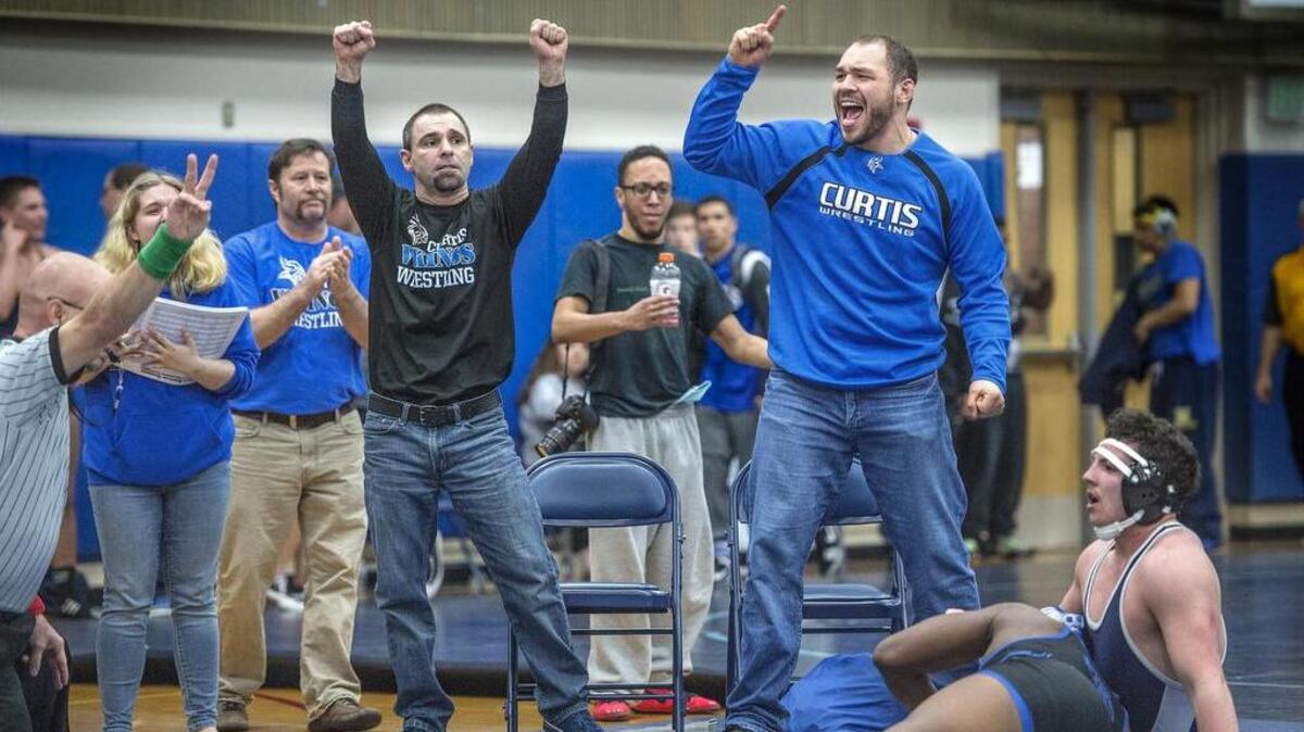 Curtis coaches Jason Baril, center, and Kalani Terukina, right, let out the emotion after their wrestler, Jay Roberts, earned two points for a takedown at the buzzer to earn a 6-4 victory over Austin Sprankle of Rogers.
