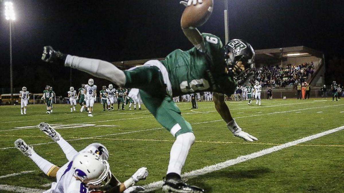 Emerald Ridge's Andrew Boston (9) leaps into the end zone for a touchdown in the second quarter. Emerald Ridge High School played Sumner High School in a football game at Sparks Stadium in Puyallup, Wash., on Friday, October 28, 2016.