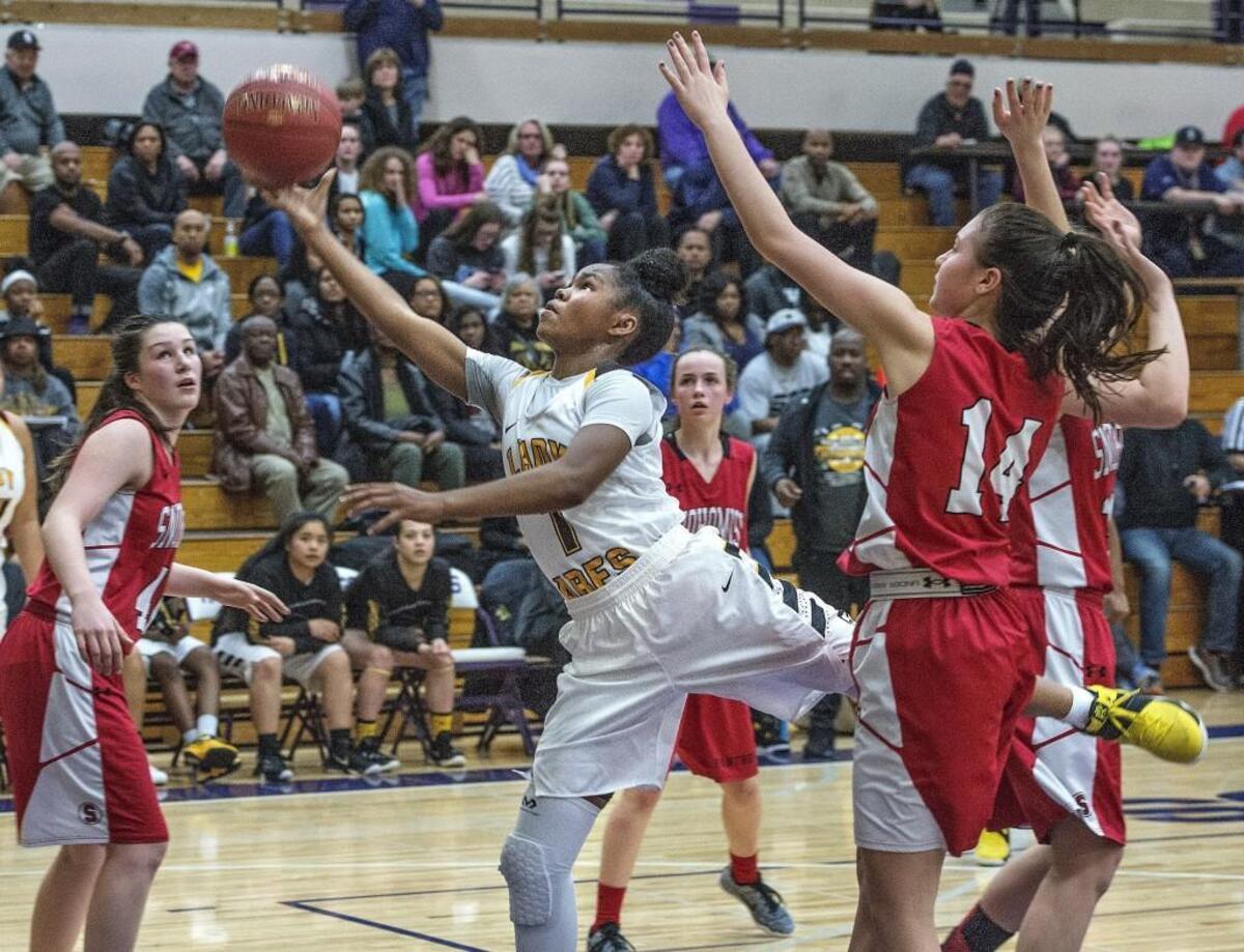 Faith Brantley of Lincoln threads through Snohomish defenders on her way to a score before losing to the Snohomish girls 41-39 in overtime during the regional game of the 3A state tournament at Puyallup H.S. Friday 2/24/17.