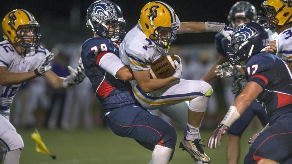 
Black Hills linebacker TJ Borden tosses around Columbia River running back Nathan Kunz during Friday night's football game at Tumwater District Stadium on Sept. 25, 2015.
