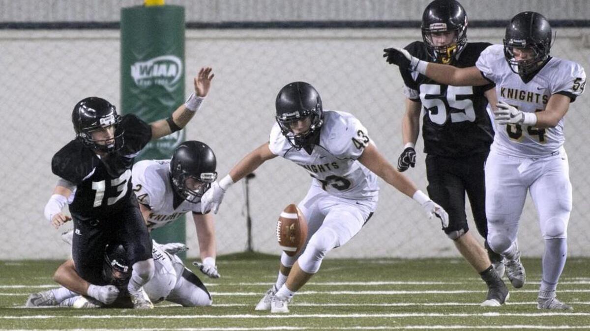 Meridian quarterback Simon Burkett (left) has the football jarred loose by Royal linebacker Alonzo Hernandez-Rangel (lower left) late in Saturday's 1A state football championship game in the Tacoma Dome. Royal's Jack Diaz (43) recovered the fumble.