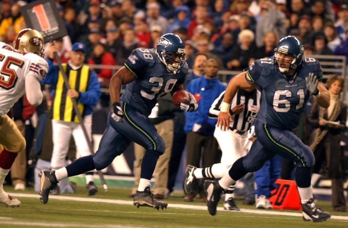 Seahawks center/guard Robbie Tobeck (#61) leads Seahawks fullback Mack Strong (#38) into the end zone for Strong's rushing touchdown in the first half. The Seattle Seahawks played the San Francisco 49ers in Seattle, Wash. on Sunday, October 12, 2003. (Bruce Kellman/The News Tribune)