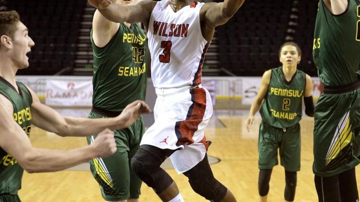 Wilson's David Jenkins Jr., who lead all scorers with 29 points, glides in for a layup between Peninsula defenders. Photo taken at Showare Center in Kent on Saturday, Dec. 19, 2015.