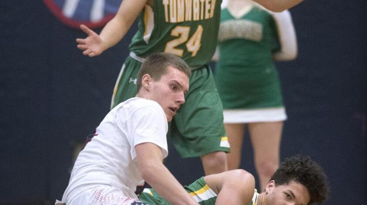 Tumwater’s Weston Weller (24) and Thomas Drayton force a turnover from post Noah Brewer of Black Hills during Friday night’s crosstown rivalry game.
