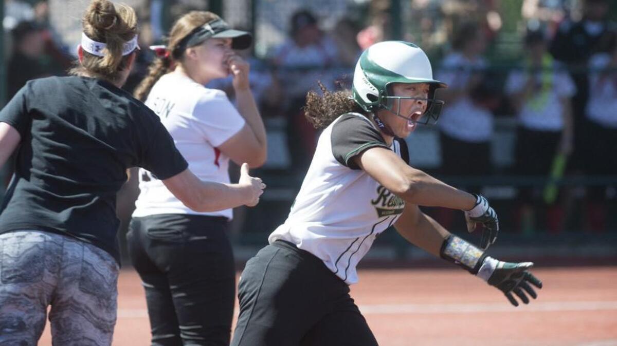 Redmond's Kiki Robinson-Milloy lets out a roar in front of Yelm first baseman Carley Nelson as her second home run of the game clears the fence, giving the Mustangs a 9-5 lead in the seventh inning of the 3A fastpitch state championship at the Regional Athletic Complex in Lacey.