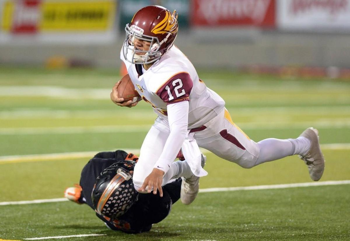 Clovis West quarterback Adrian Martinez gets tripped up by Central's Mathew Mendoza on a keeper play in their Tri-River Athletic Conference football duel at Central Friday, Oct. 28, 2016.