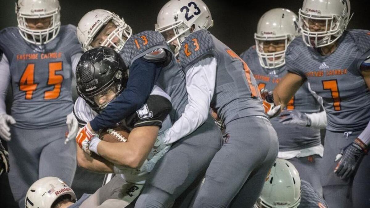 Bonney Lake’s Jason Day protects the ball against a host of Eastside Catholic defenders Friday at Memorial Stadium in Seattle. Eastside Catholic rolled to a 47-7 Class 3A state quarterfinal victory and will face Lakes in the semifinals on Nov. 27 or 28.