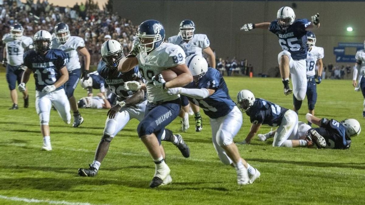 Gonzaga Prep’s Evan Weaver drags Bellarmine Prep defenders into the end zone.