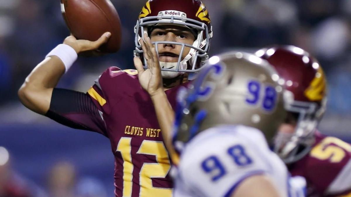 Clovis West quarterback Adrian Martinez, background, throws a lateral against Clovis Friday night, Nov. 4. 2016 in Clovis, Calif.